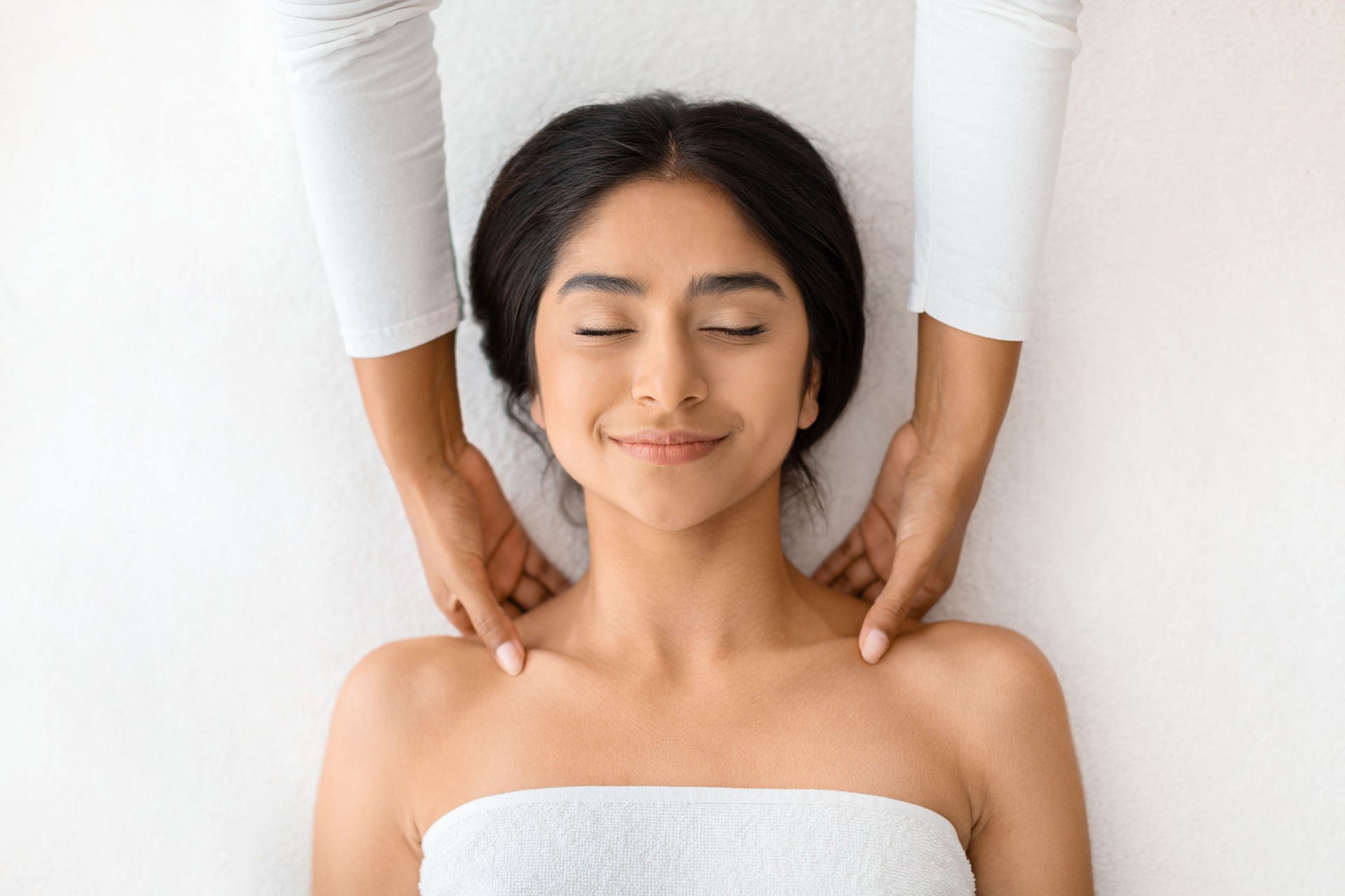 Top view of indian woman receiving relaxing shoulder massage